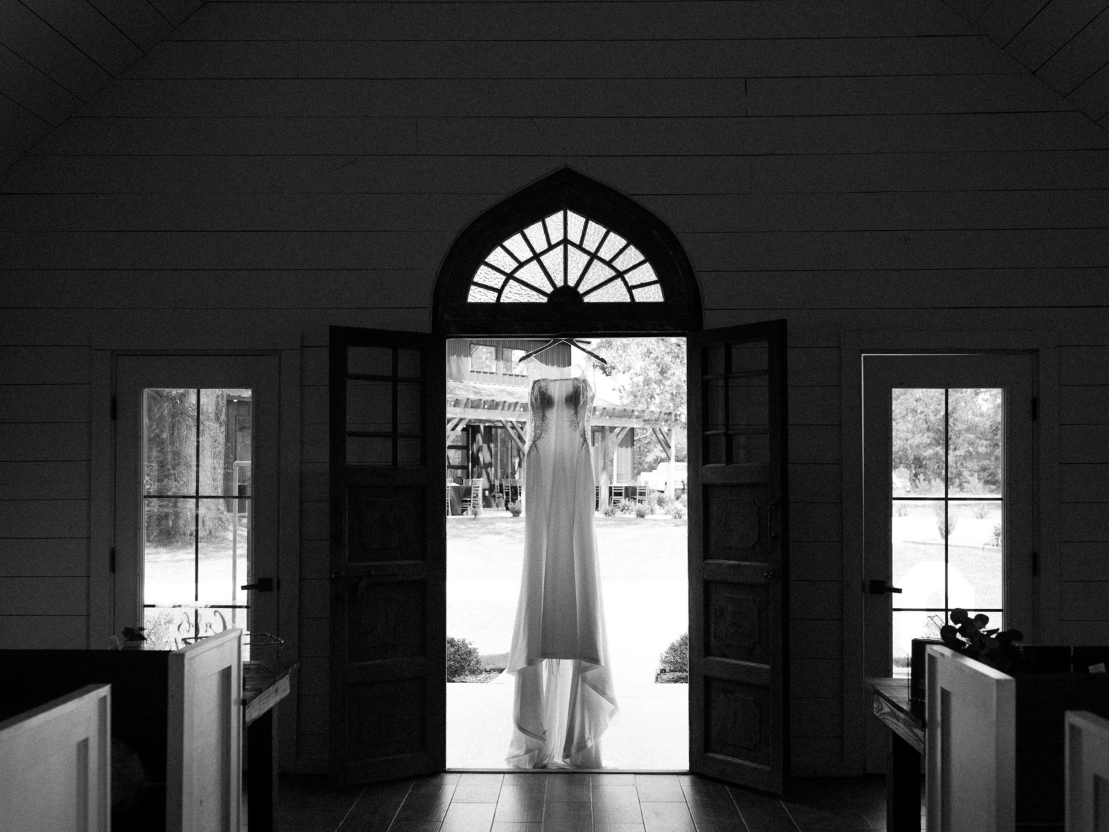 bride's wedding dress hanging from church doorway