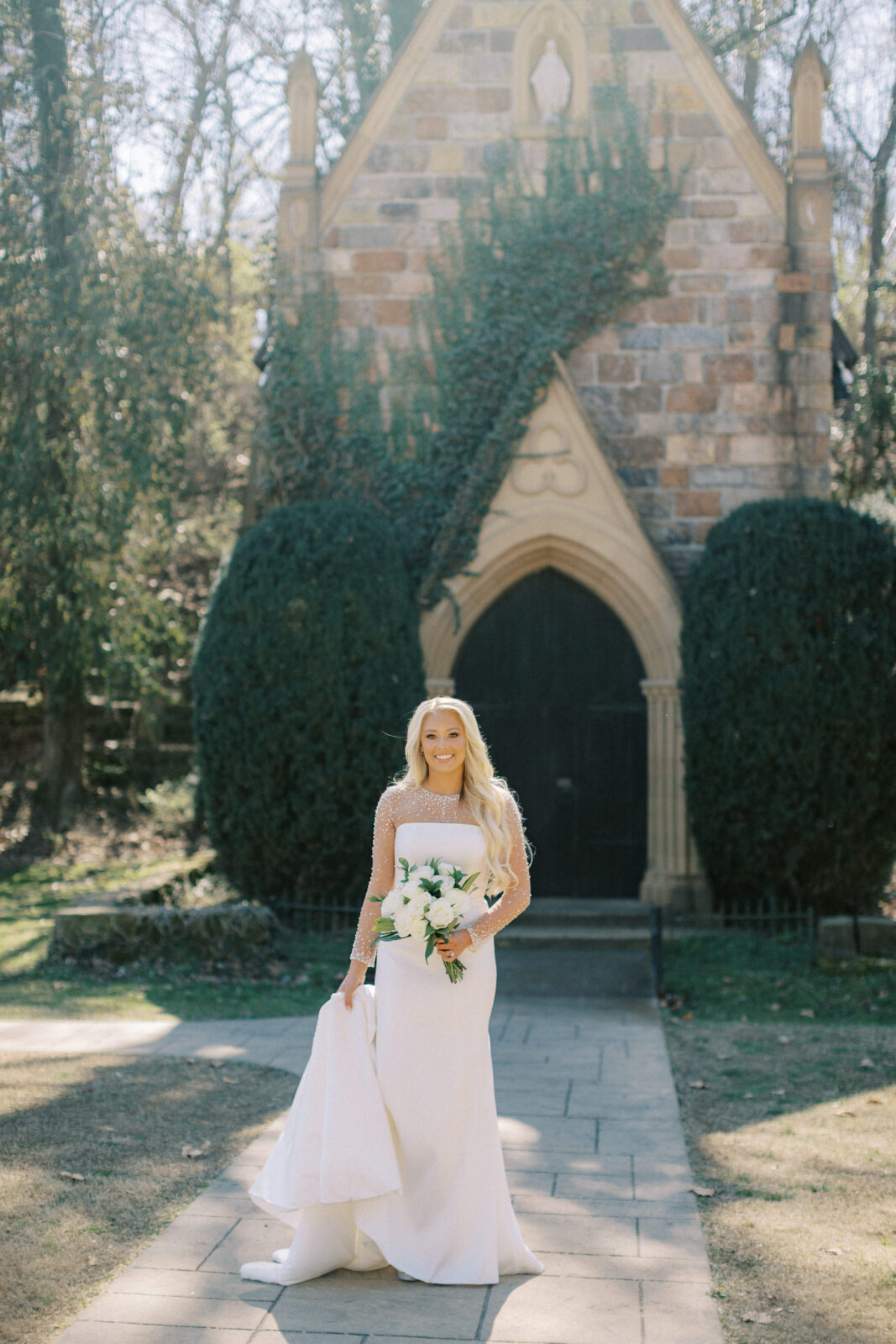 Bride standing outside the stone chapel at St. Catherine’s at Bell Gable