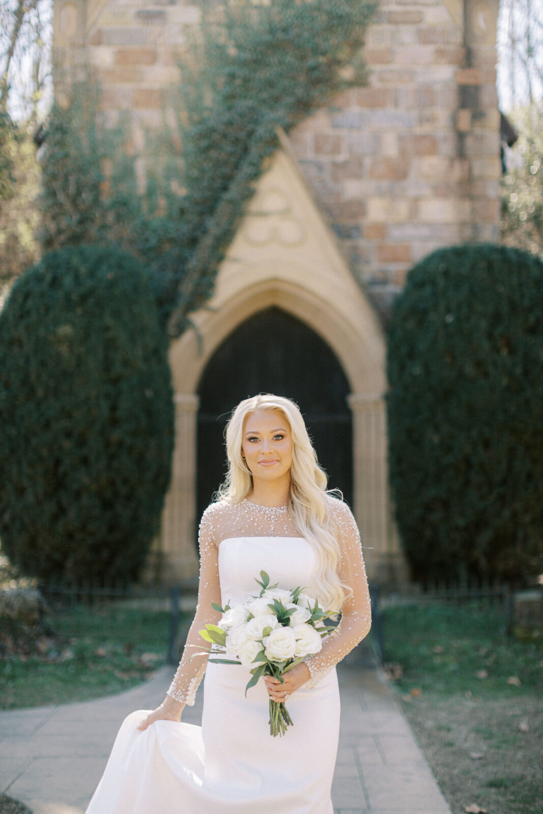 Grace posing in her wedding gown at St. Catherine’s at Bell Gable in Fayetteville, Arkansas