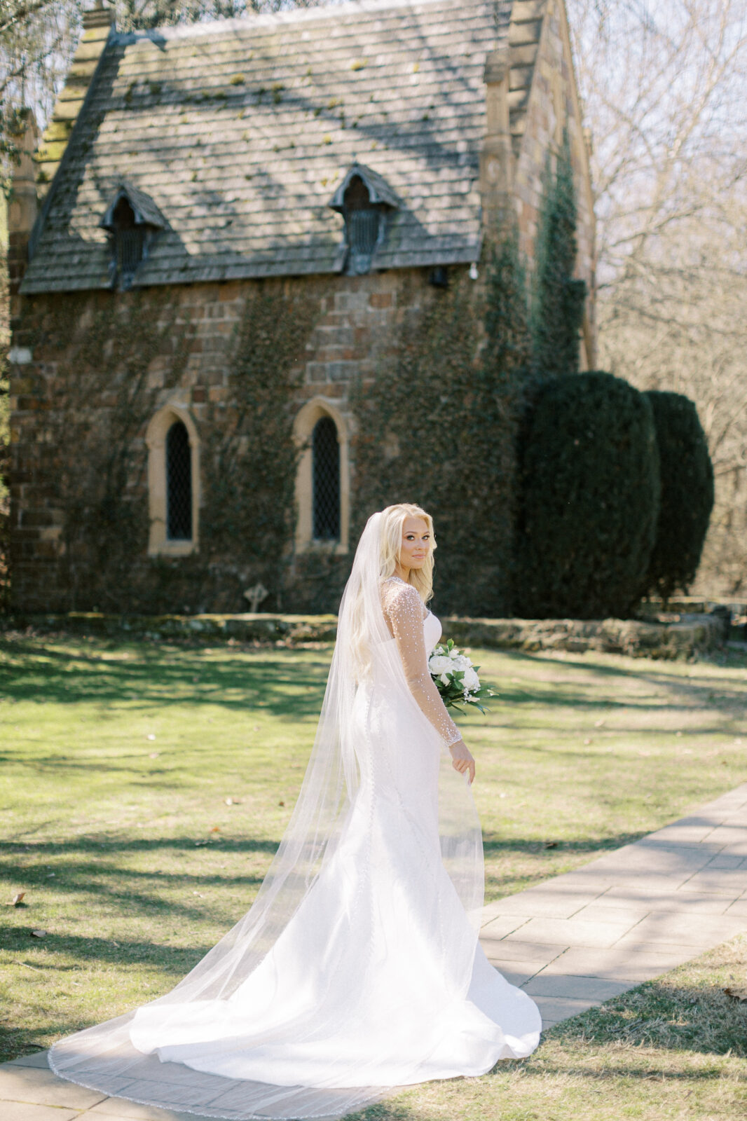 Bride standing outside the stone chapel at St. Catherine’s at Bell Gable