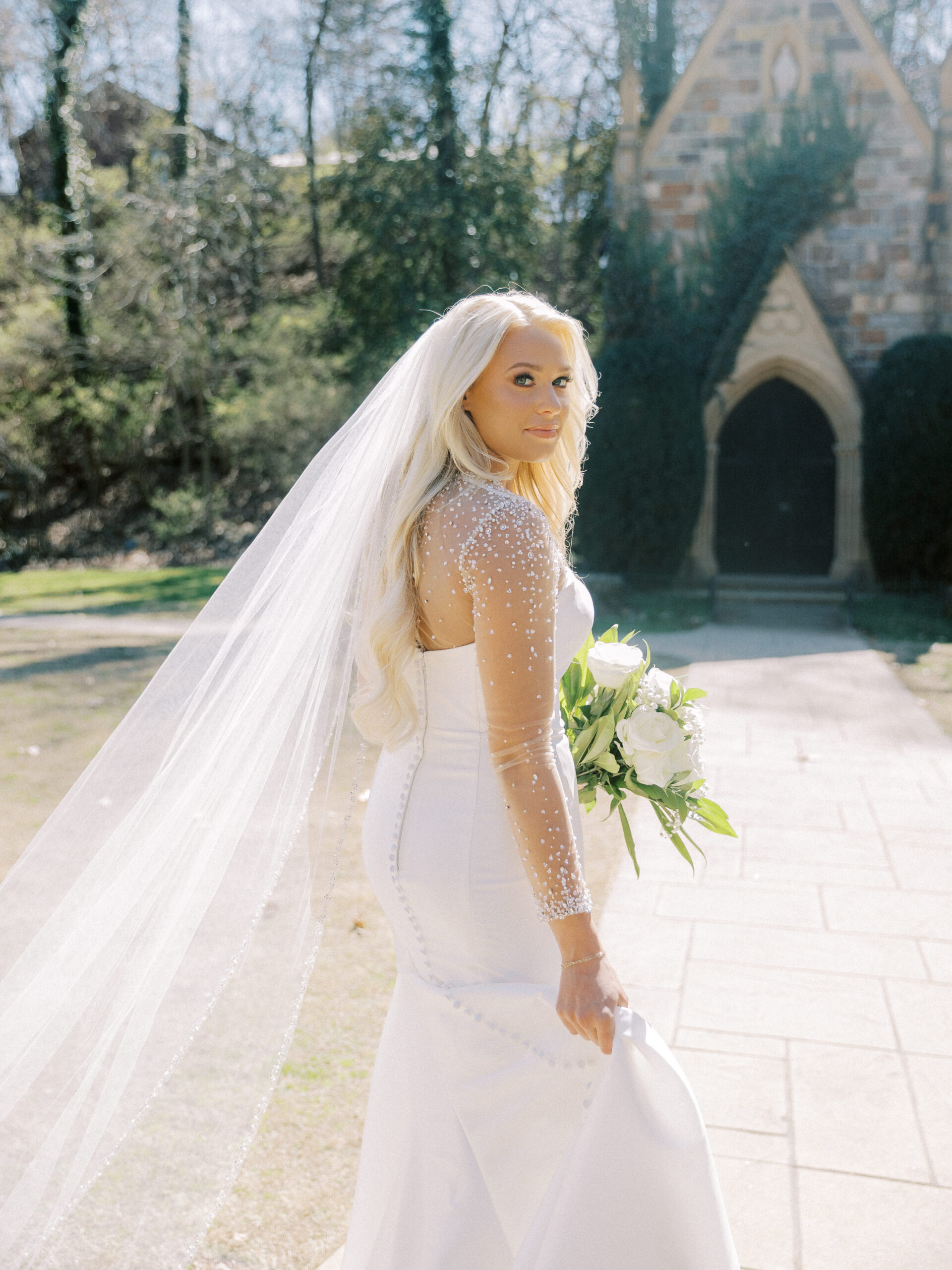 Bride standing outside the stone chapel at St. Catherine’s at Bell Gable