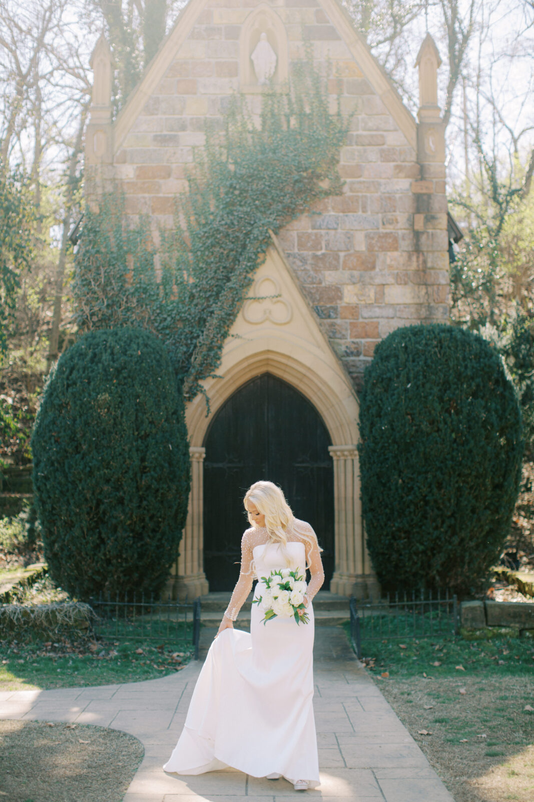 Bride standing outside the stone chapel at St. Catherine’s at Bell Gable
